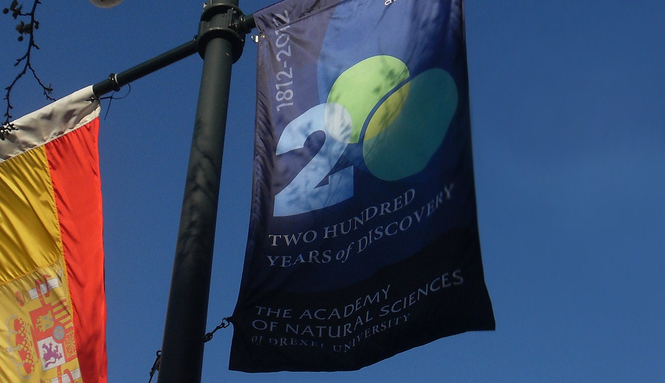 Photo of a banner on a pole with the a logo displayed on it